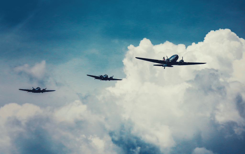 Three planes flying through cloudy skies