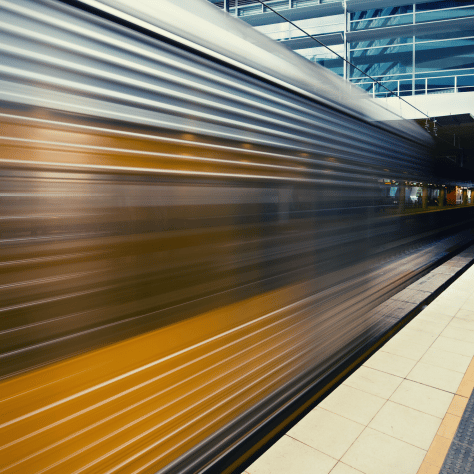 Train passing by station platform with motion blur