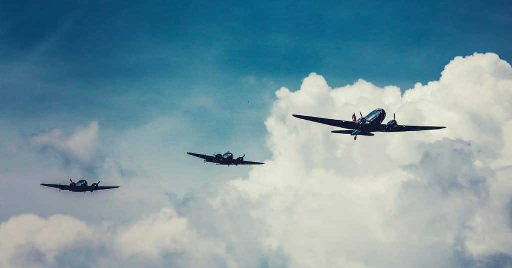 Three planes flying through cloudy skies