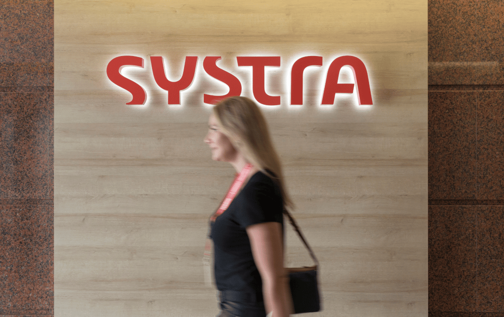Woman walking past systra logo
