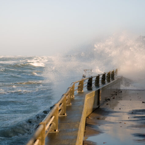 Høje bølger slår ind over dige