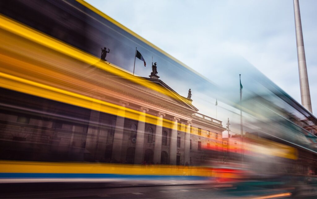 Dublin bus passing The Spire of Dublin and the general post office.