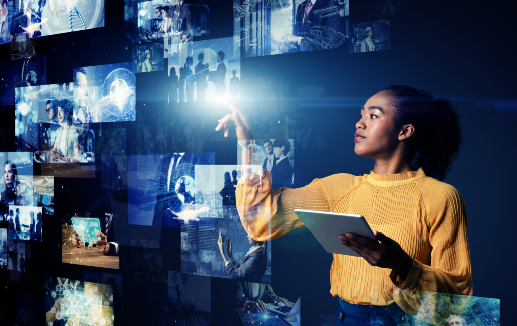 Image of a woman in a yellow jumper looking at various images of people, and groups of people, floating in front of her. She is pointing at one of the images. The graphic symbolises social and market research.