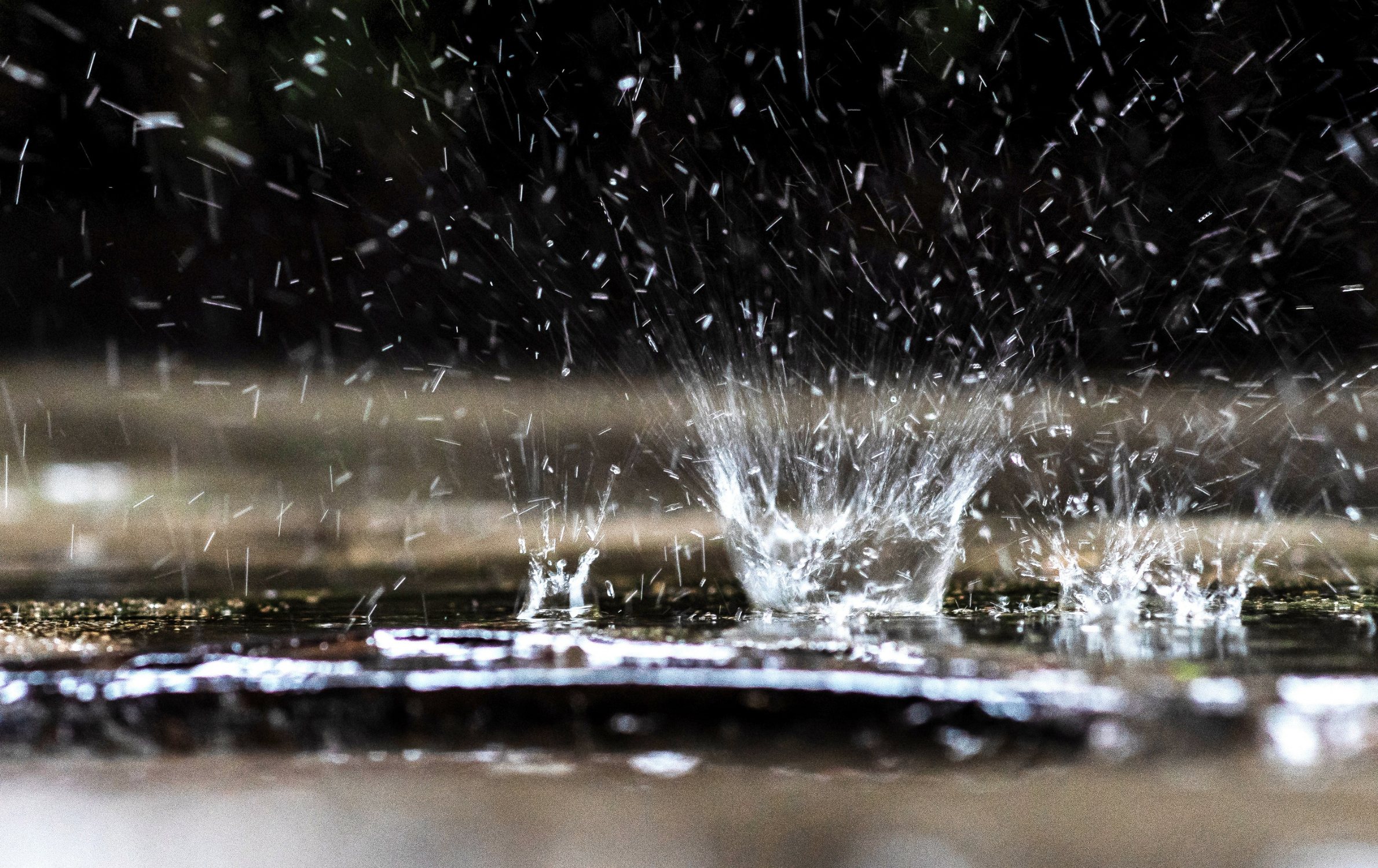 Image of rainwater falling on the ground and splashing.