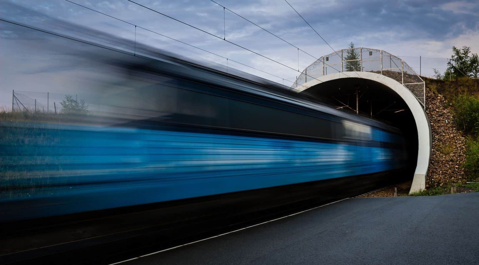 A long exposure photograph of a train going in or out of a tunnel.