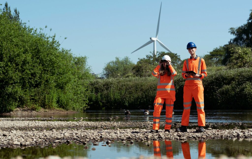SYSTRA specialists on a site inspection with wind turbine behind