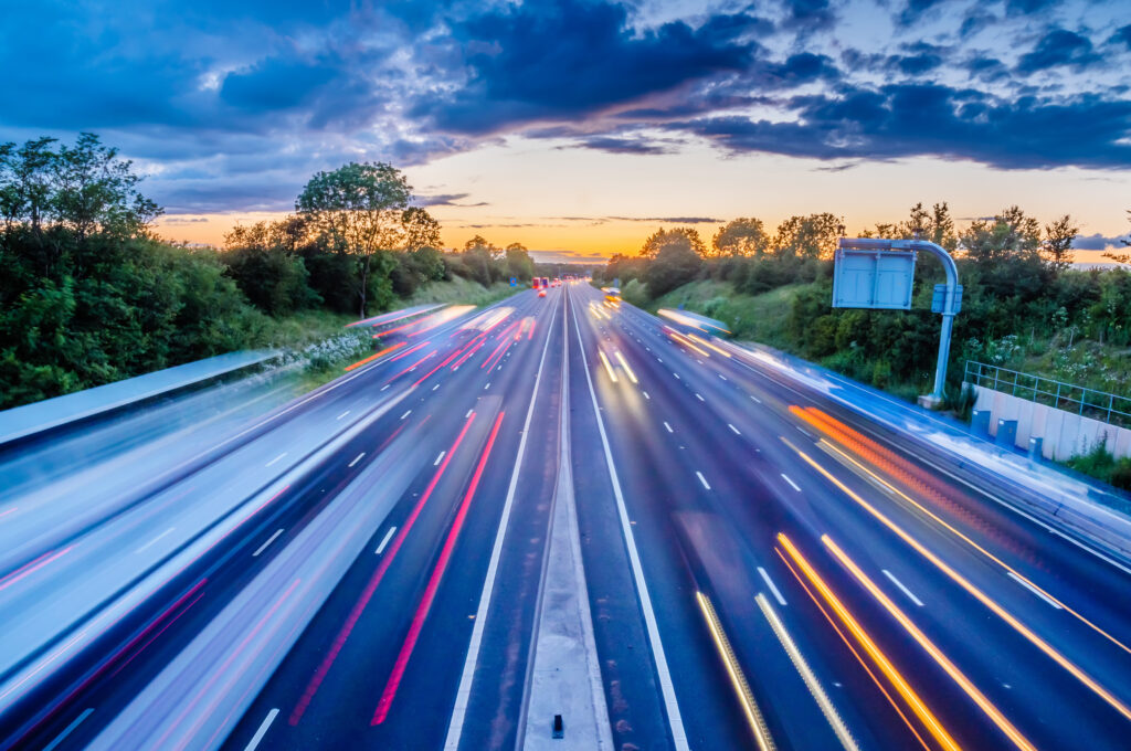 heavy traffic moving at speed on UK motorway in England at sunset