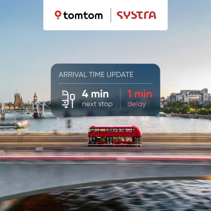 A photo of a red bus driving along a bridge over the River Thames in London. The bridge and water is motion blurred. You can see Big Ben in the distance. Overlayed on the photo in the middle is a transparent navy blue box that says 'arrival time update, 4 min next stop, 1 min delay'. The '1 min delay' text is in red and the rest is in white. At the top of the photo is a white box overlayed. Inside the box on the left is the tomtom logo and on the right is the SYSTRA logo.