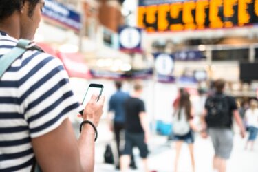 Person on mobile phone at in London Liverpool Street train station