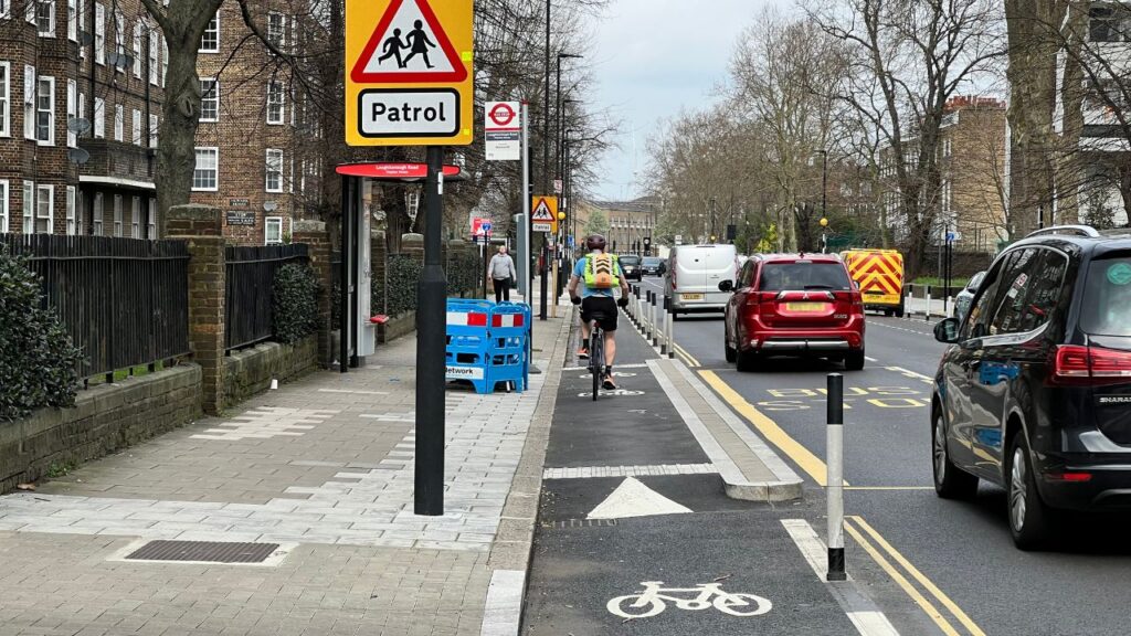 Cycle lane in Lambeth with cyclist and school sign