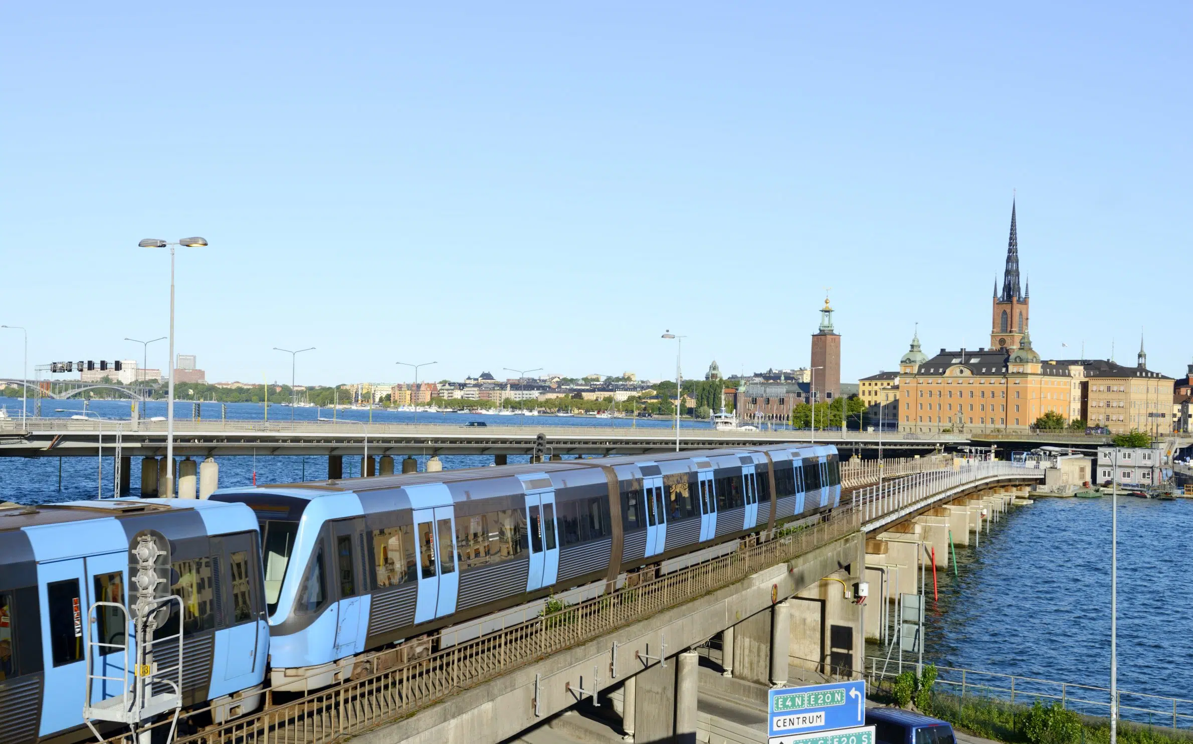 Et blått metrotog kjører over en bro i Stockholm